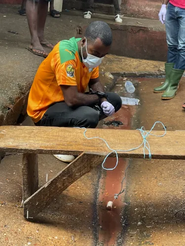 a man in orange T-Shirts setting up passive sample of water