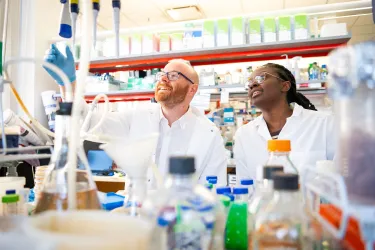 two people in lab coats in a lab at the Graduate School of Biomedical Sciences at Tufts