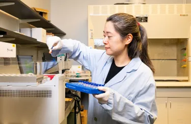 a woman in a light blue lab coat in the Innovation Hub for Food and Materials