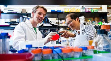 Dr. John Leong with a graduate student in a laboratory