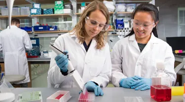 Assistant Professor of Biomedical Engineering Madeleine Oudin and a female student in the lab
