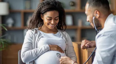 Black pregnant woman being examined by her physician