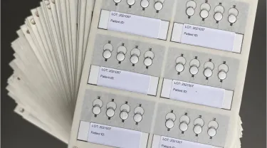 A number of paper cards with tabs for information and patient numbers. Tufts researchers collaborate with scientists in South Africa to trial a more precise medical device to measure HIV viral loads