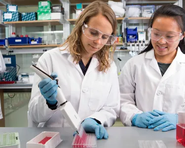 Assistant Professor of Biomedical Engineering Madeleine Oudin and a female student in the lab