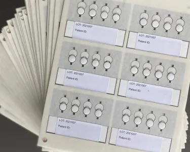 A number of paper cards with tabs for information and patient numbers. Tufts researchers collaborate with scientists in South Africa to trial a more precise medical device to measure HIV viral loads
