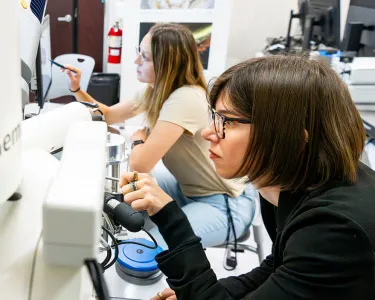 Two women in a lab working with lab equipment
